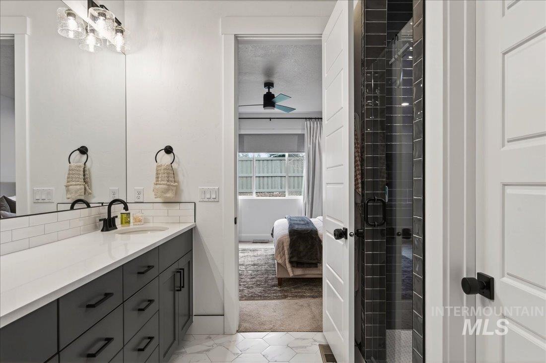 Bathroom with ensuite bathroom, vanity, a stall shower, and light colored carpet