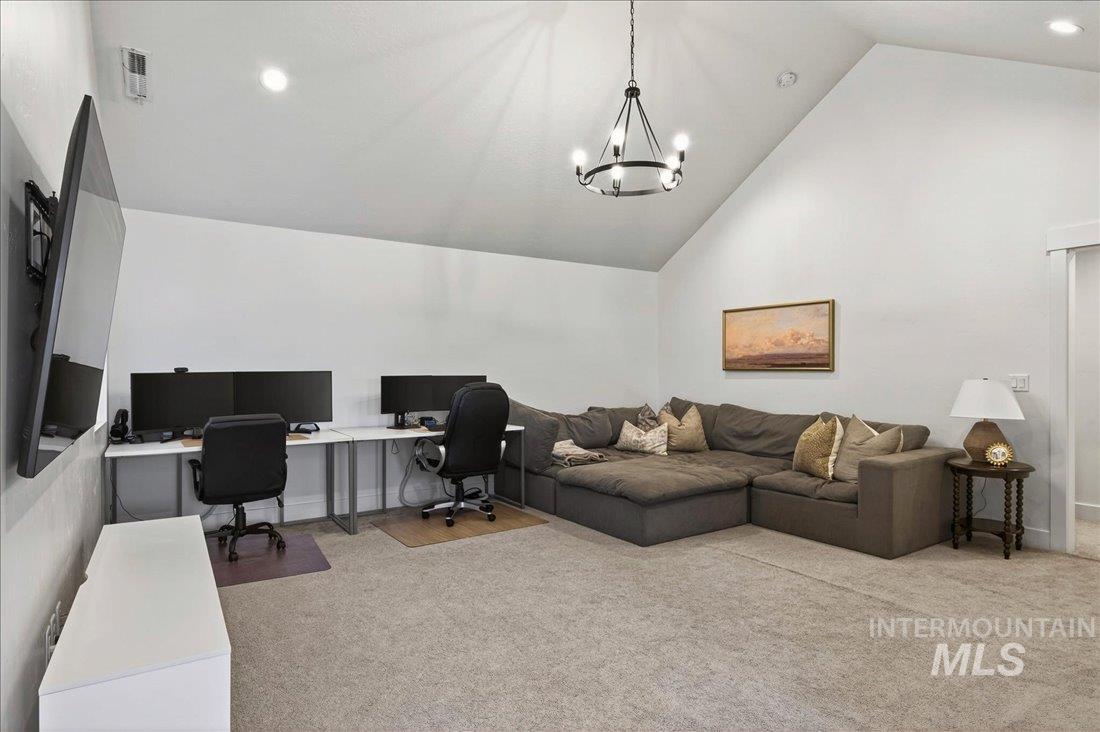 Office area featuring recessed lighting, light carpet, high vaulted ceiling, and a chandelier
