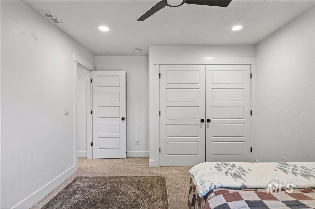 Bedroom featuring light colored carpet, a closet, a ceiling fan, and recessed lighting