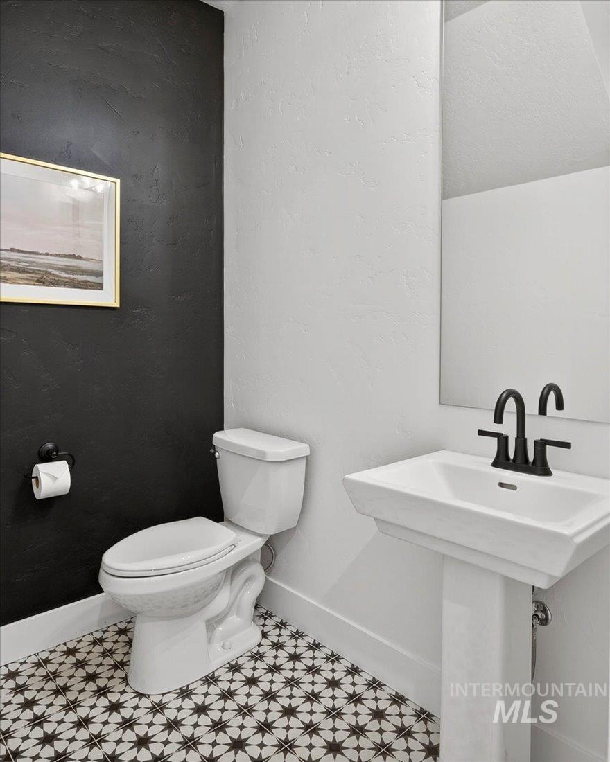 Half bathroom with a textured wall and toilet