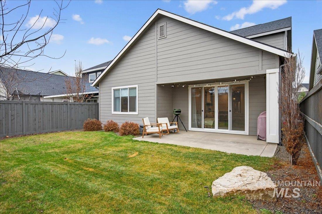 Rear view of house featuring a fenced backyard and a patio