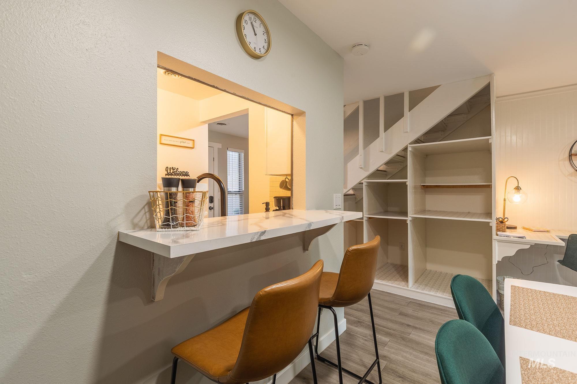 Bar area with wood finished floors and stairway