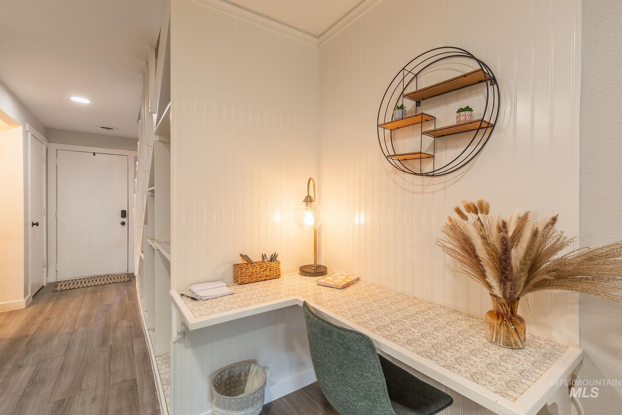 Hall with wood finished floors and ornamental molding