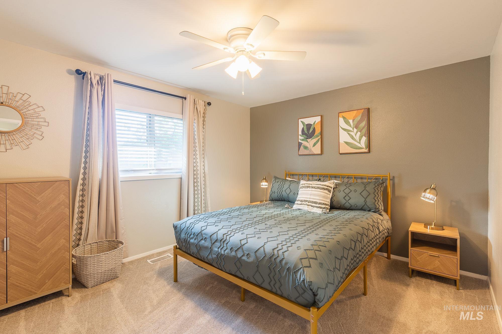 Carpeted bedroom with baseboards and a ceiling fan