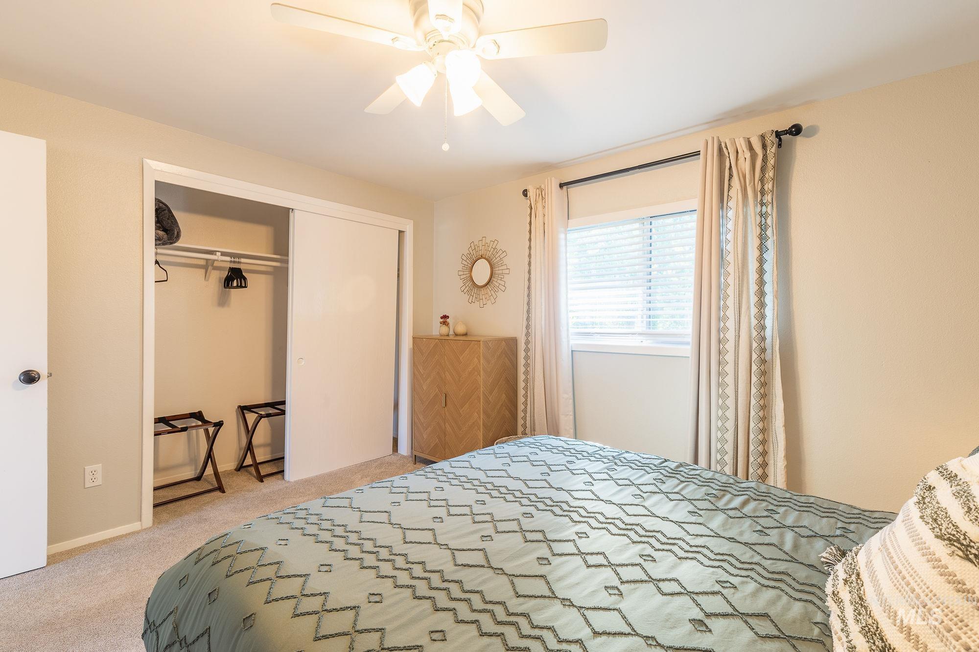 Carpeted bedroom featuring a closet and a ceiling fan