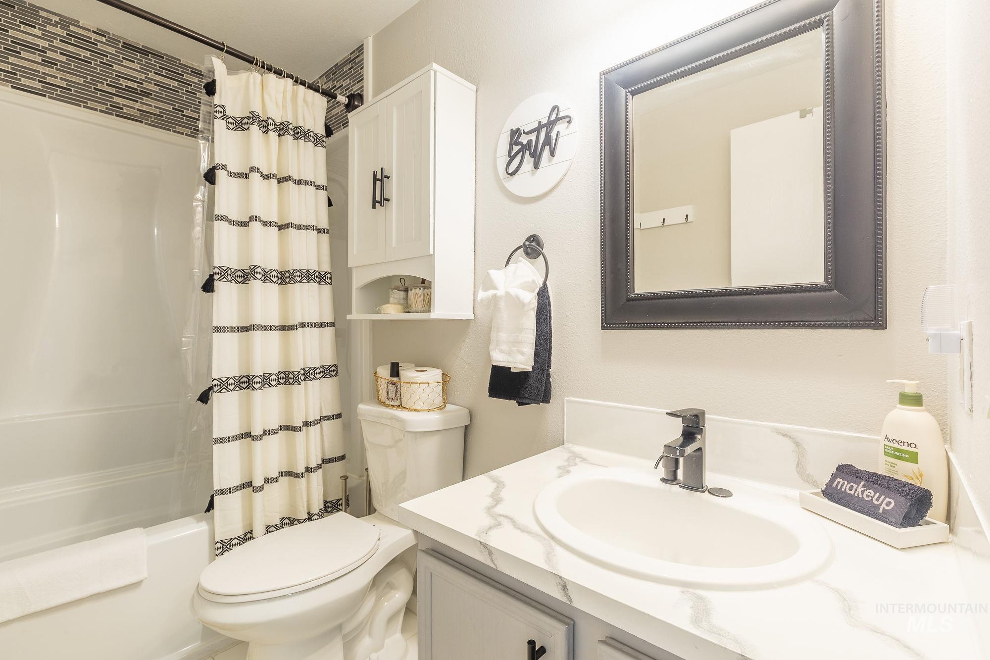 Bathroom with vanity and shower / bath combination with curtain