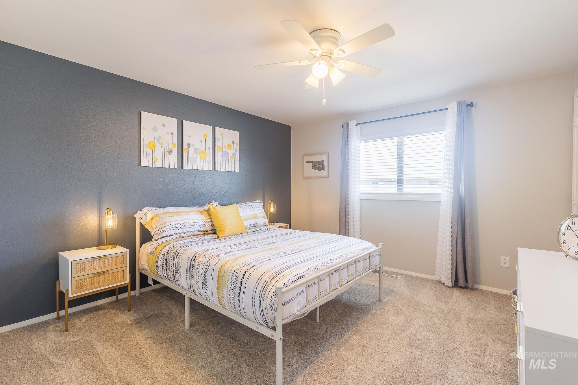 Bedroom with light carpet and a ceiling fan