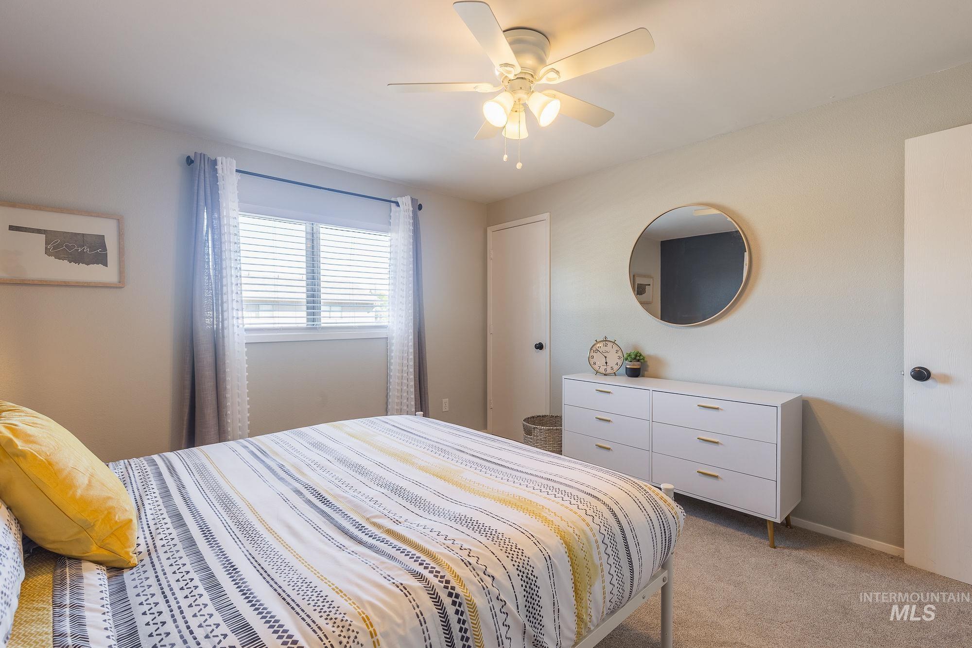 Bedroom featuring light carpet and a ceiling fan