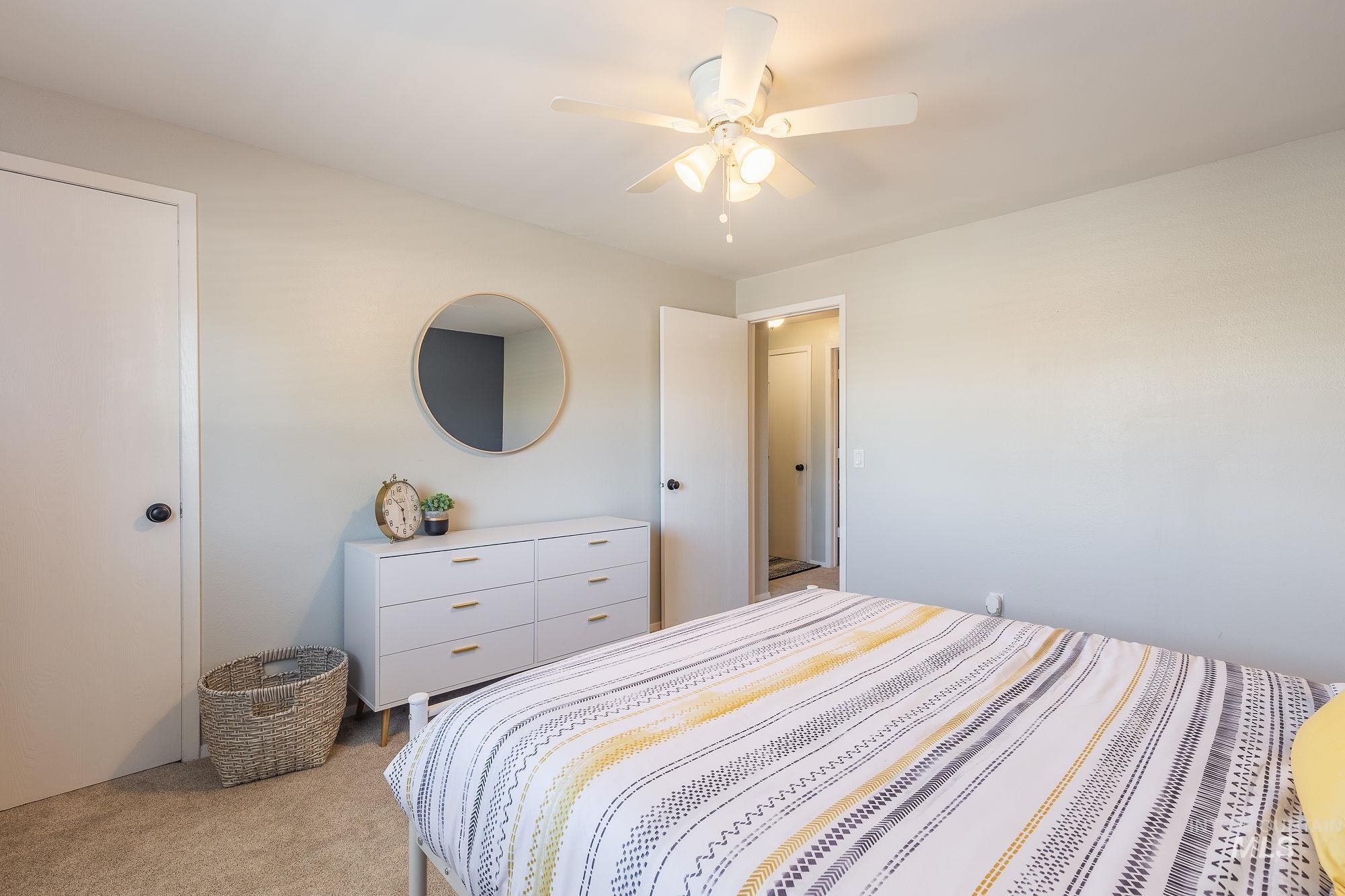 Bedroom with light carpet and a ceiling fan