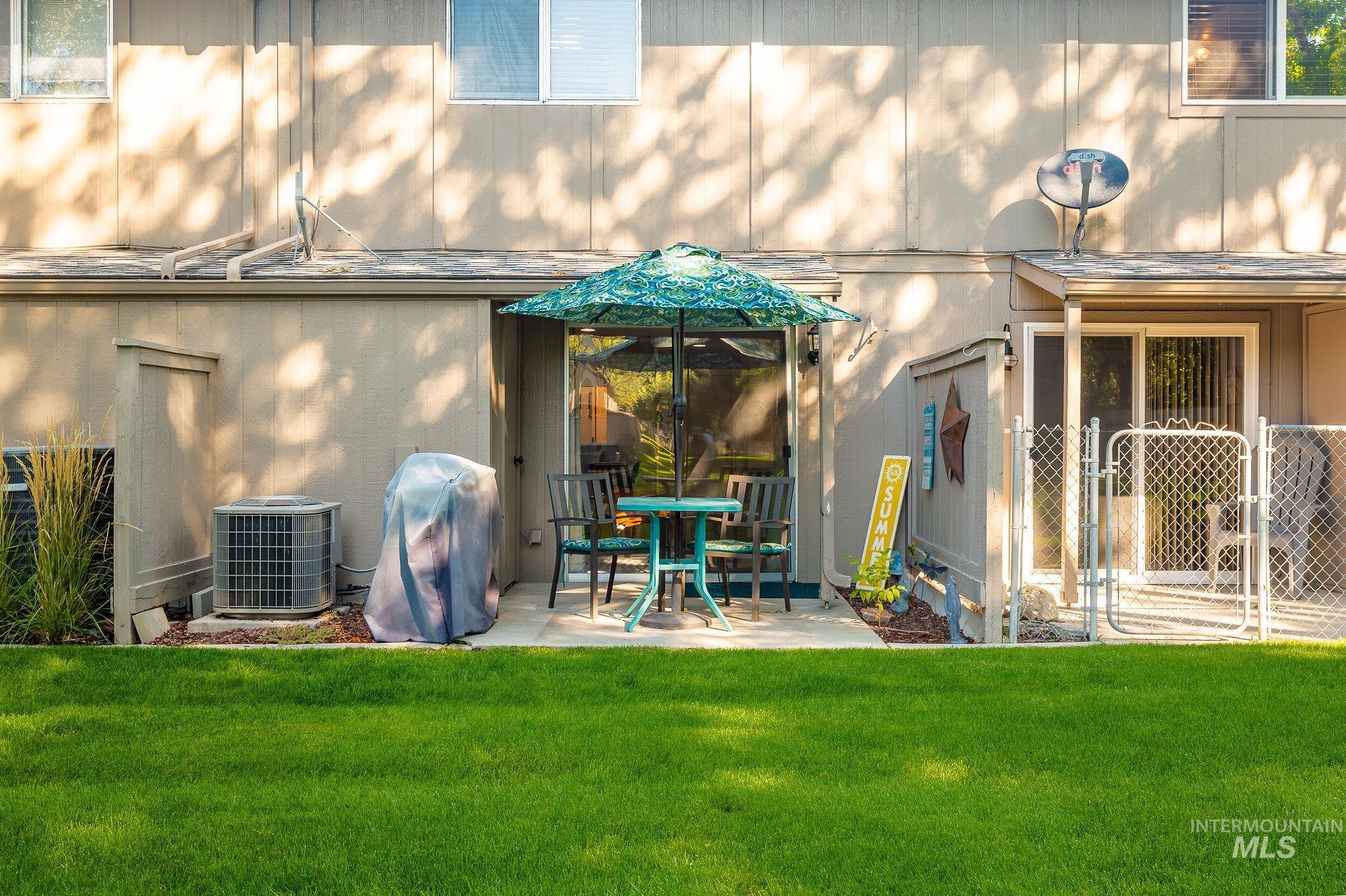 Rear view of property with a lawn and a patio area