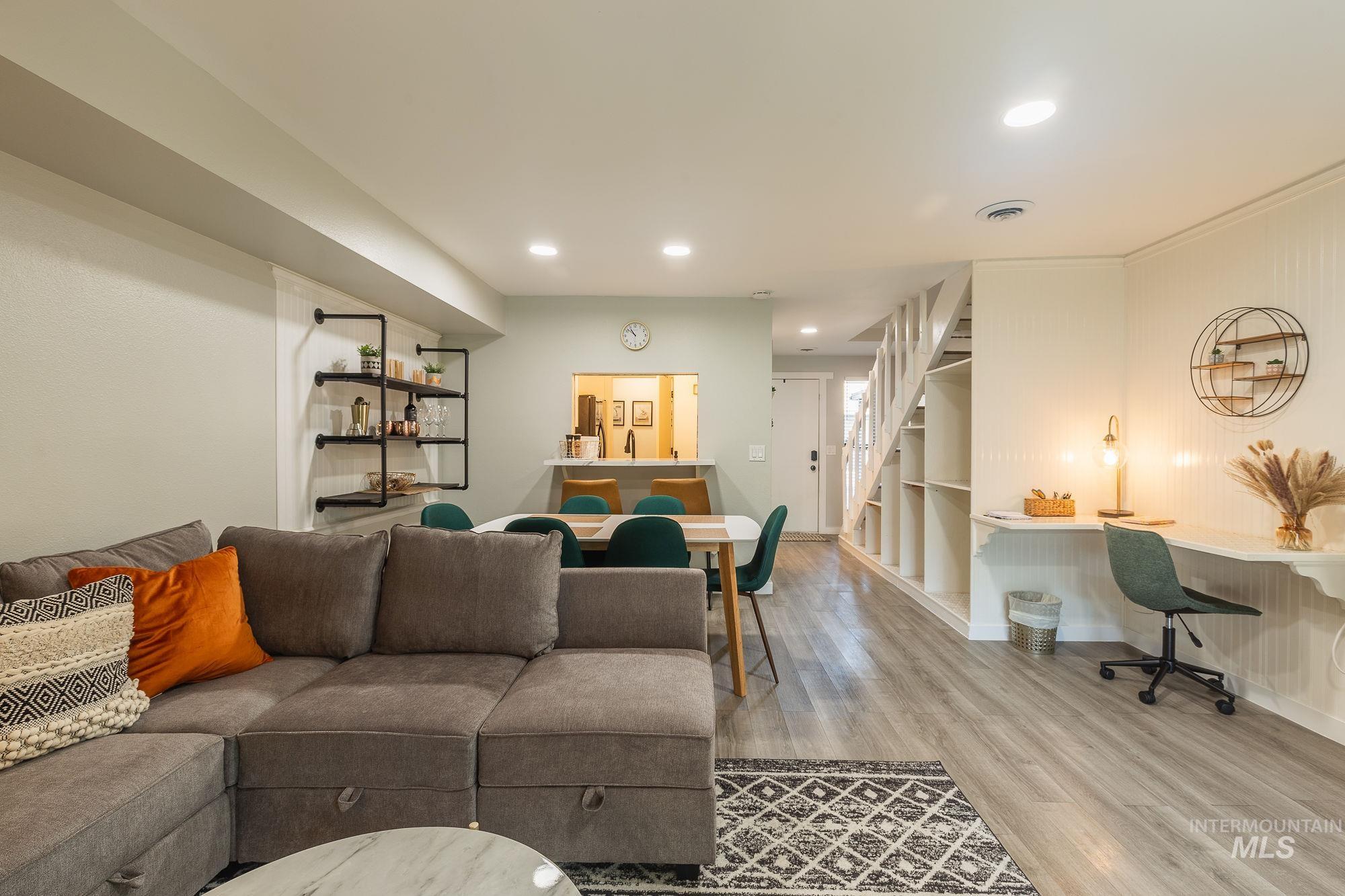 Living area with wood finished floors, stairway, and recessed lighting