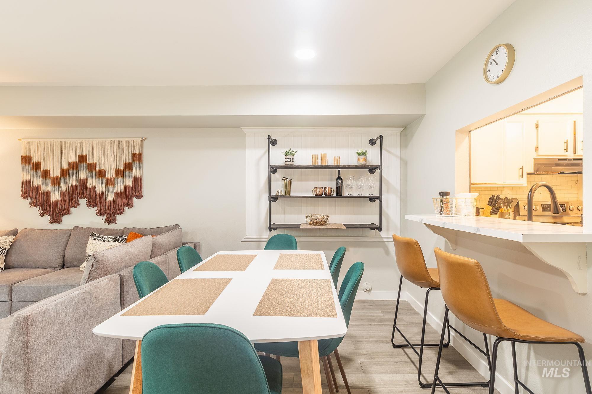 Dining area with light wood-style flooring and recessed lighting