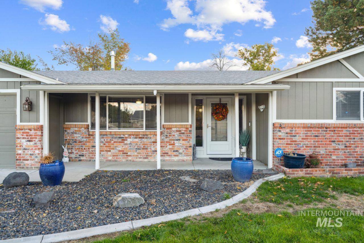 Property entrance featuring a porch, brick siding, and board and batten siding