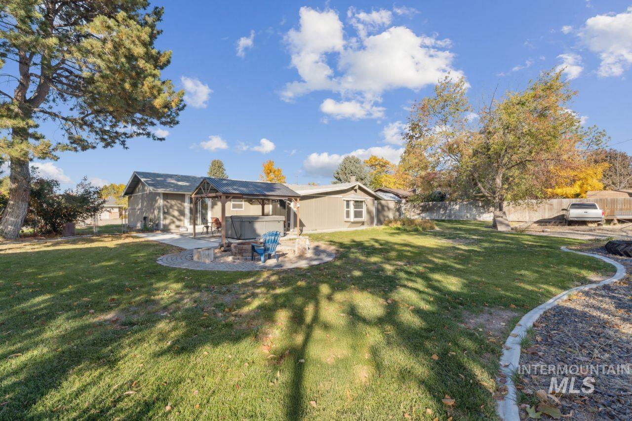 Back of property featuring a patio, a hot tub, and a fenced backyard
