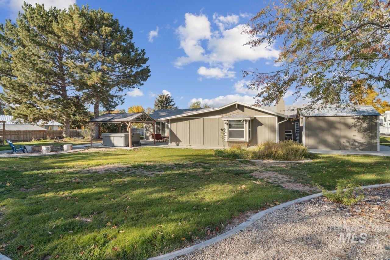 View of front of property with a patio area, a hot tub, and a gazebo