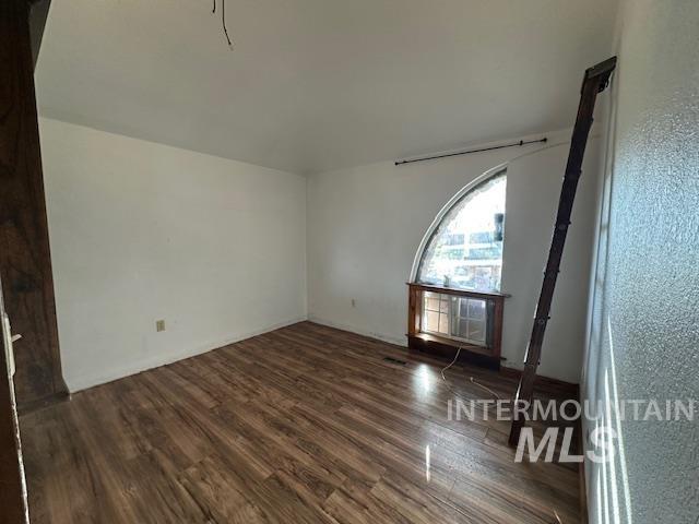 Empty room with dark wood-type flooring