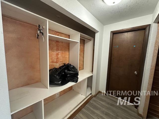 Mudroom with dark wood-style floors and a textured ceiling