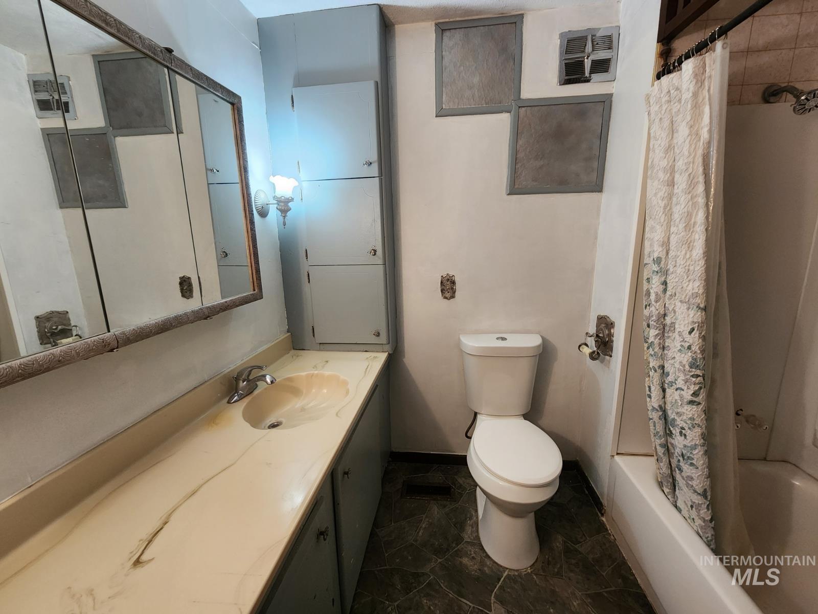 Bathroom featuring vanity and shower / tub combo with curtain
