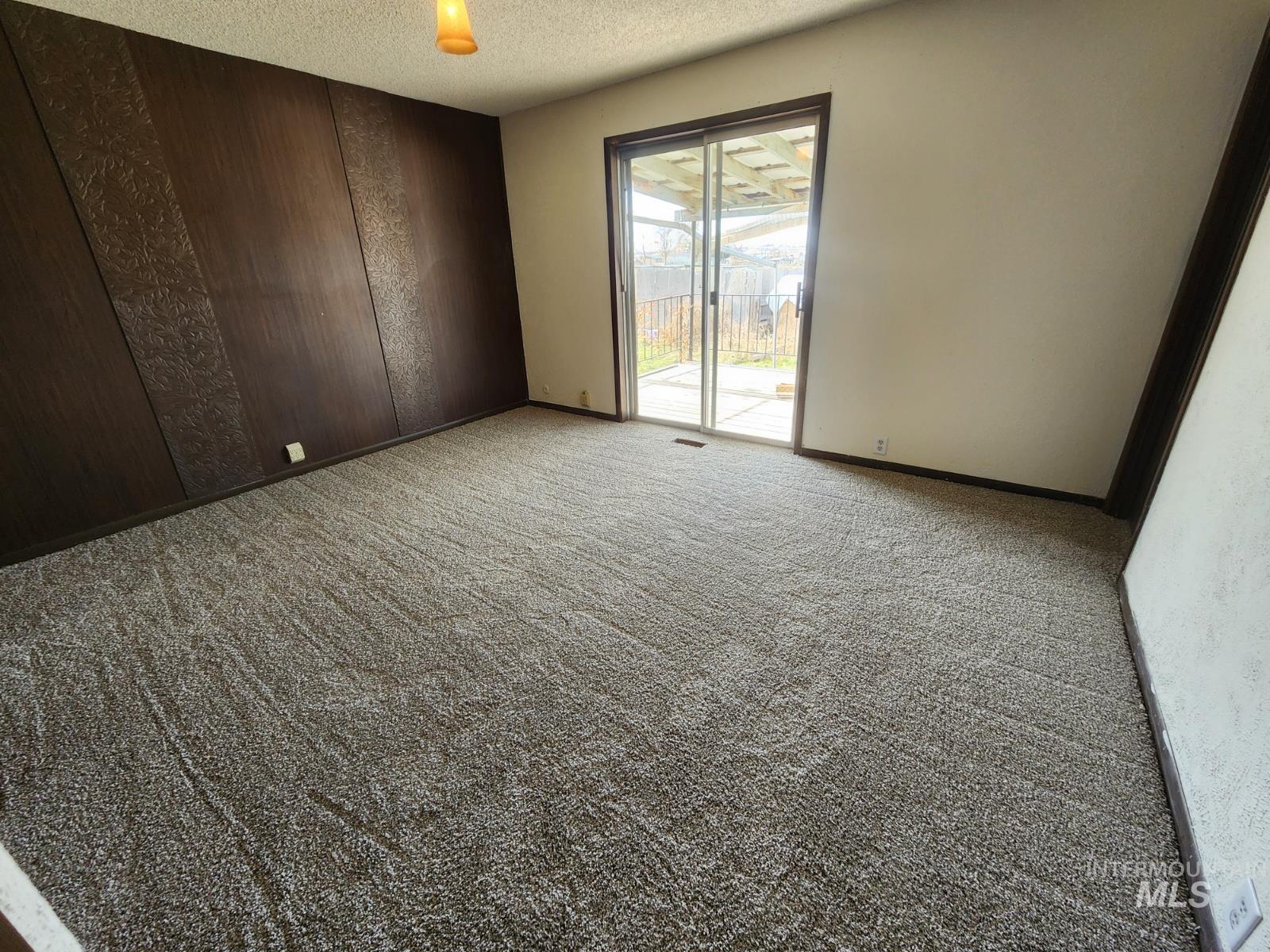 Spare room with a textured ceiling and light carpet