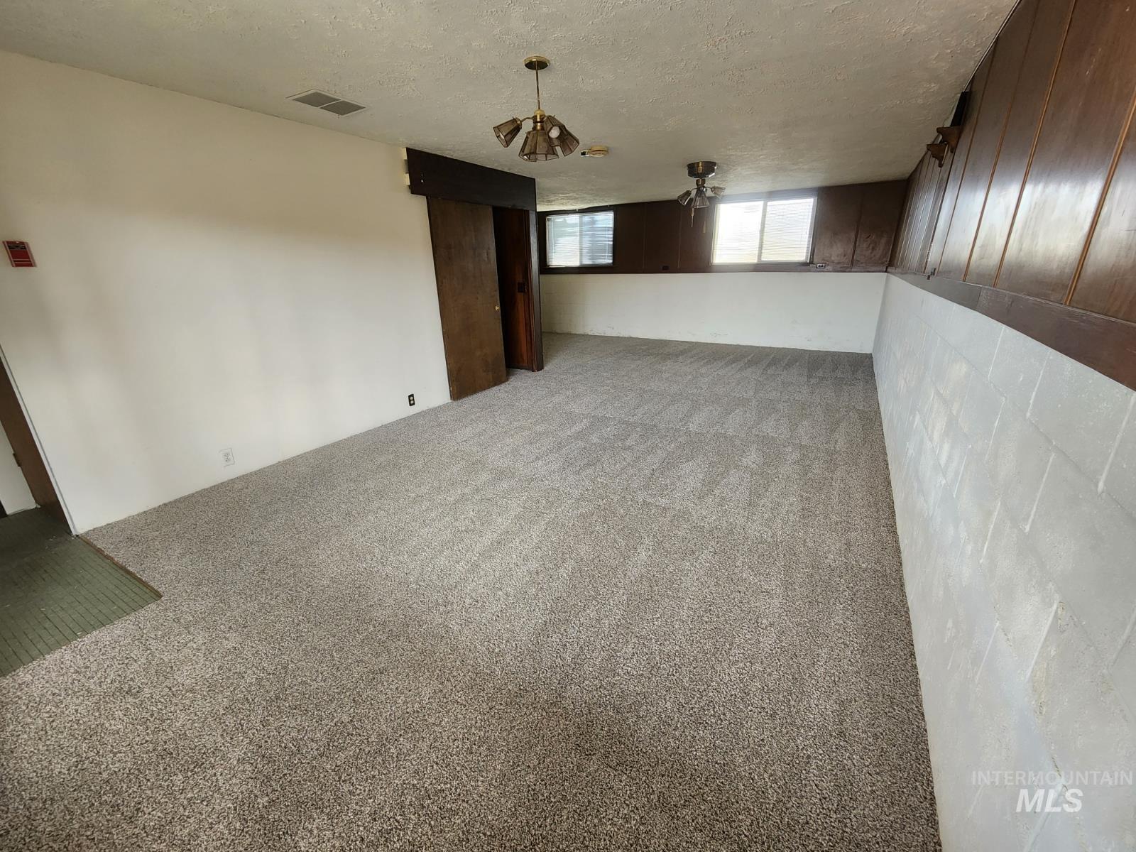 Below grade area with carpet flooring and a textured ceiling