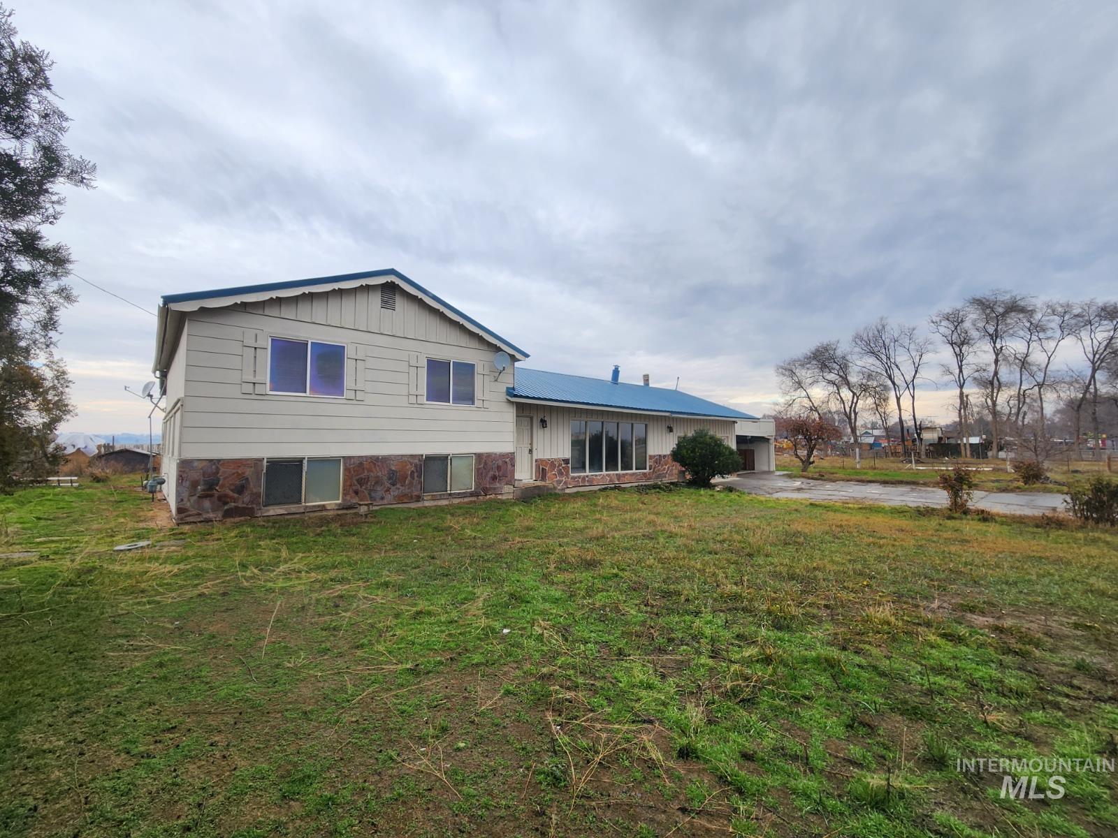Back of house with a yard, concrete driveway, board and batten siding, and a garage