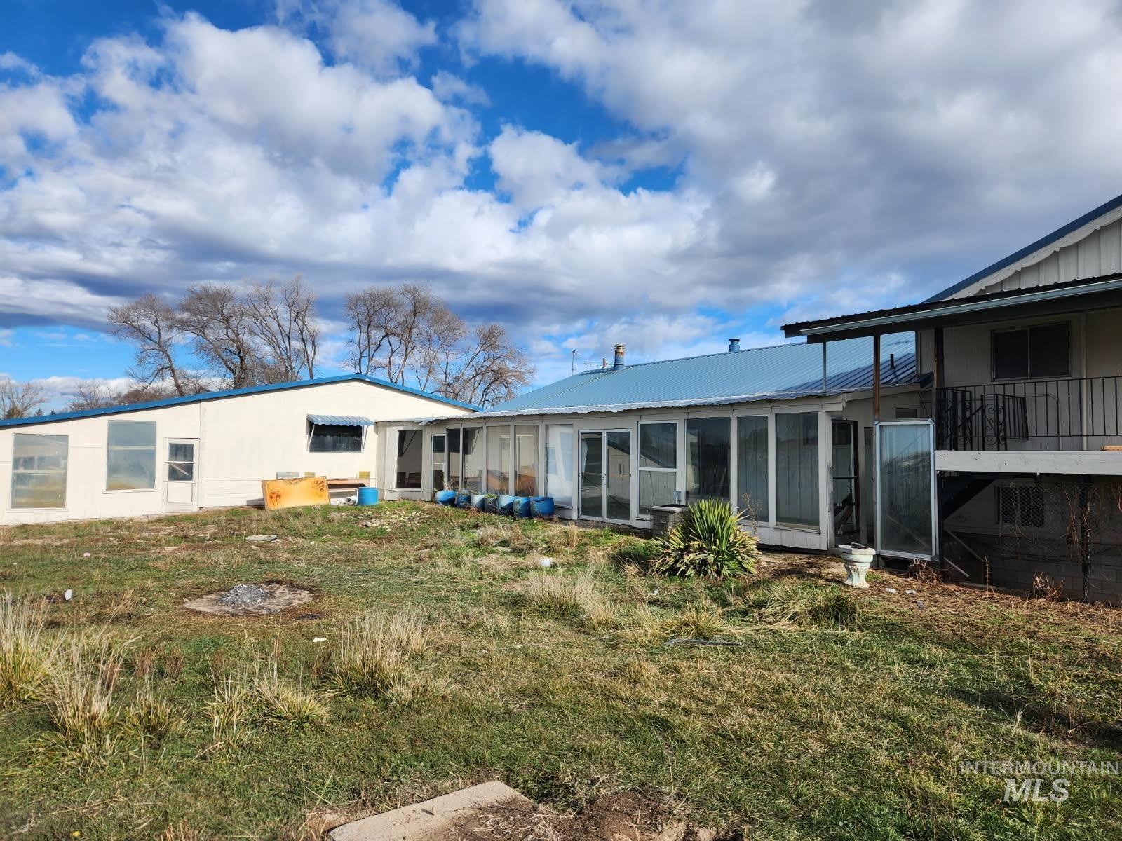Back of house with a sunroom and a metal roof