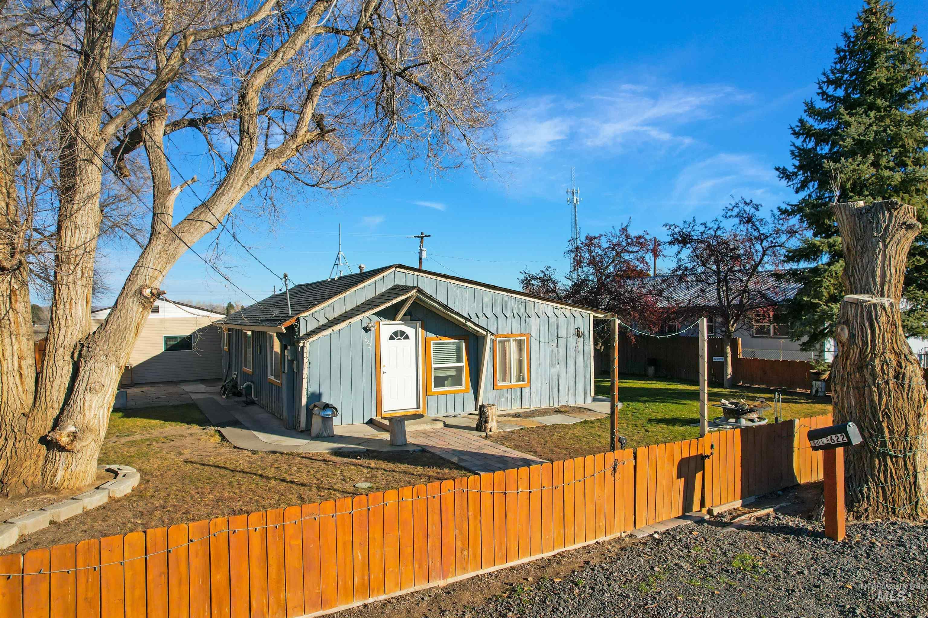 View of front facade with board and batten siding and a fenced front yard