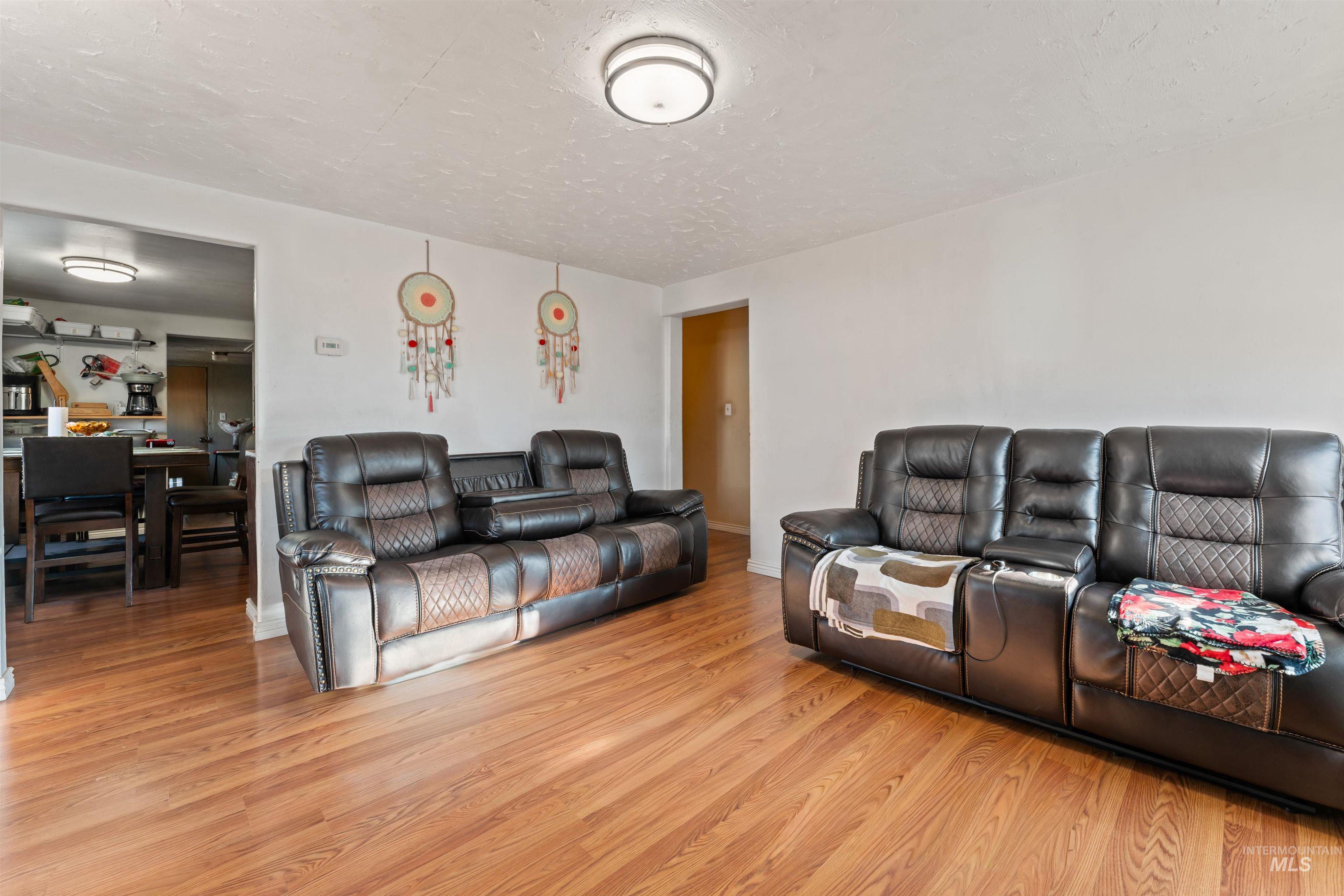 Living area featuring light wood-style flooring and a textured ceiling