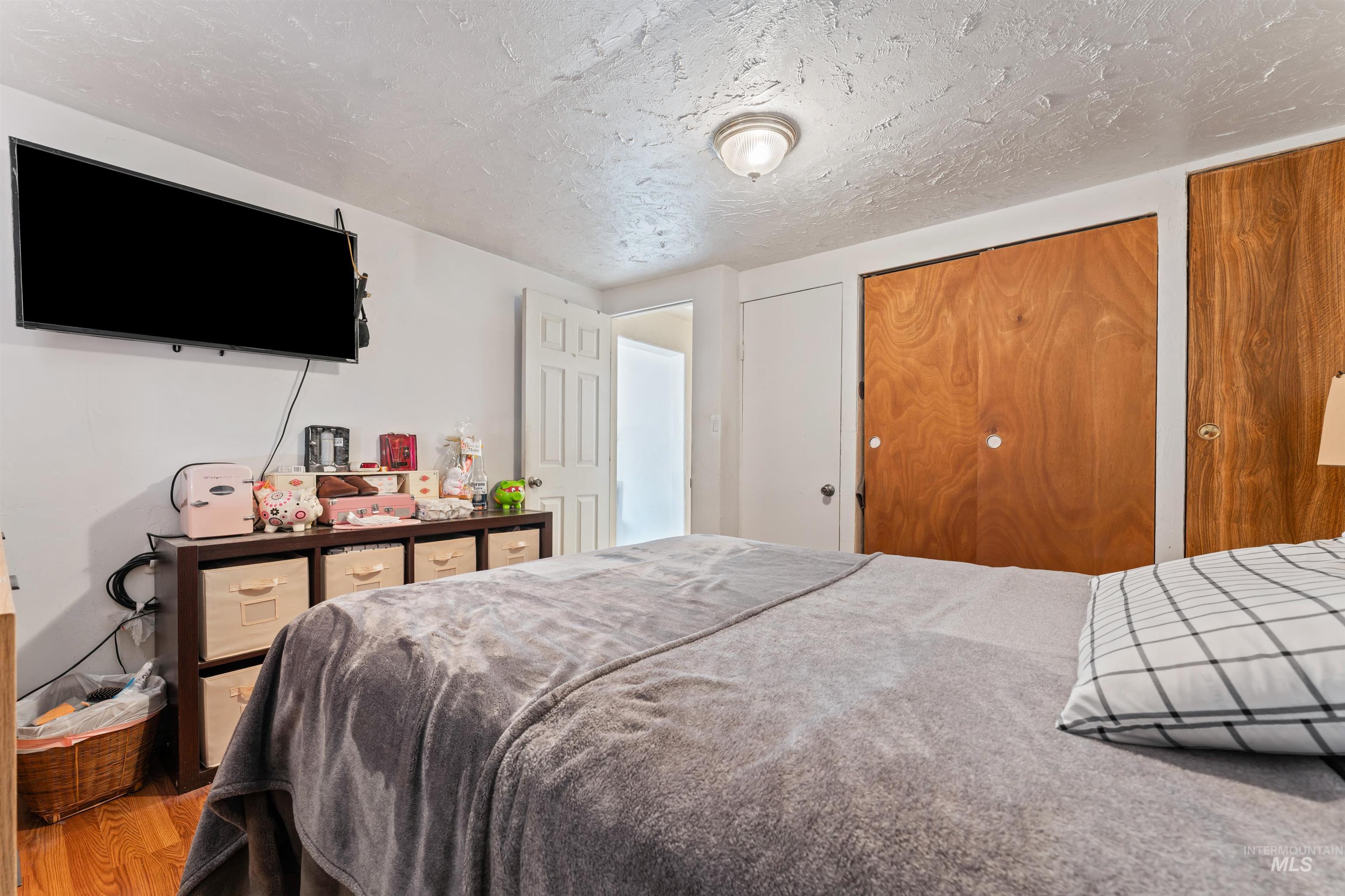 Bedroom featuring a closet, a textured ceiling, and wood finished floors