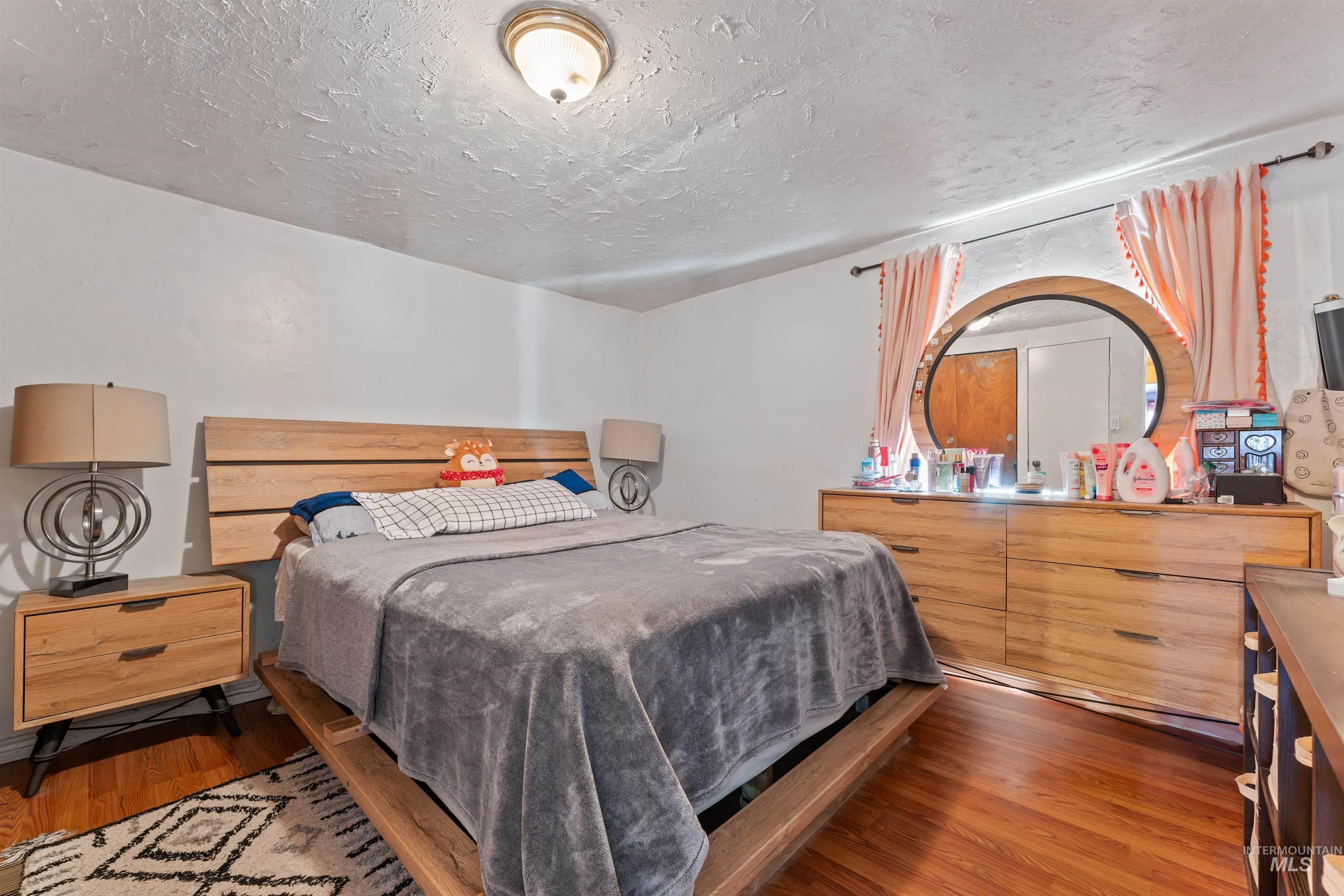 Bedroom featuring wood finished floors and a textured ceiling