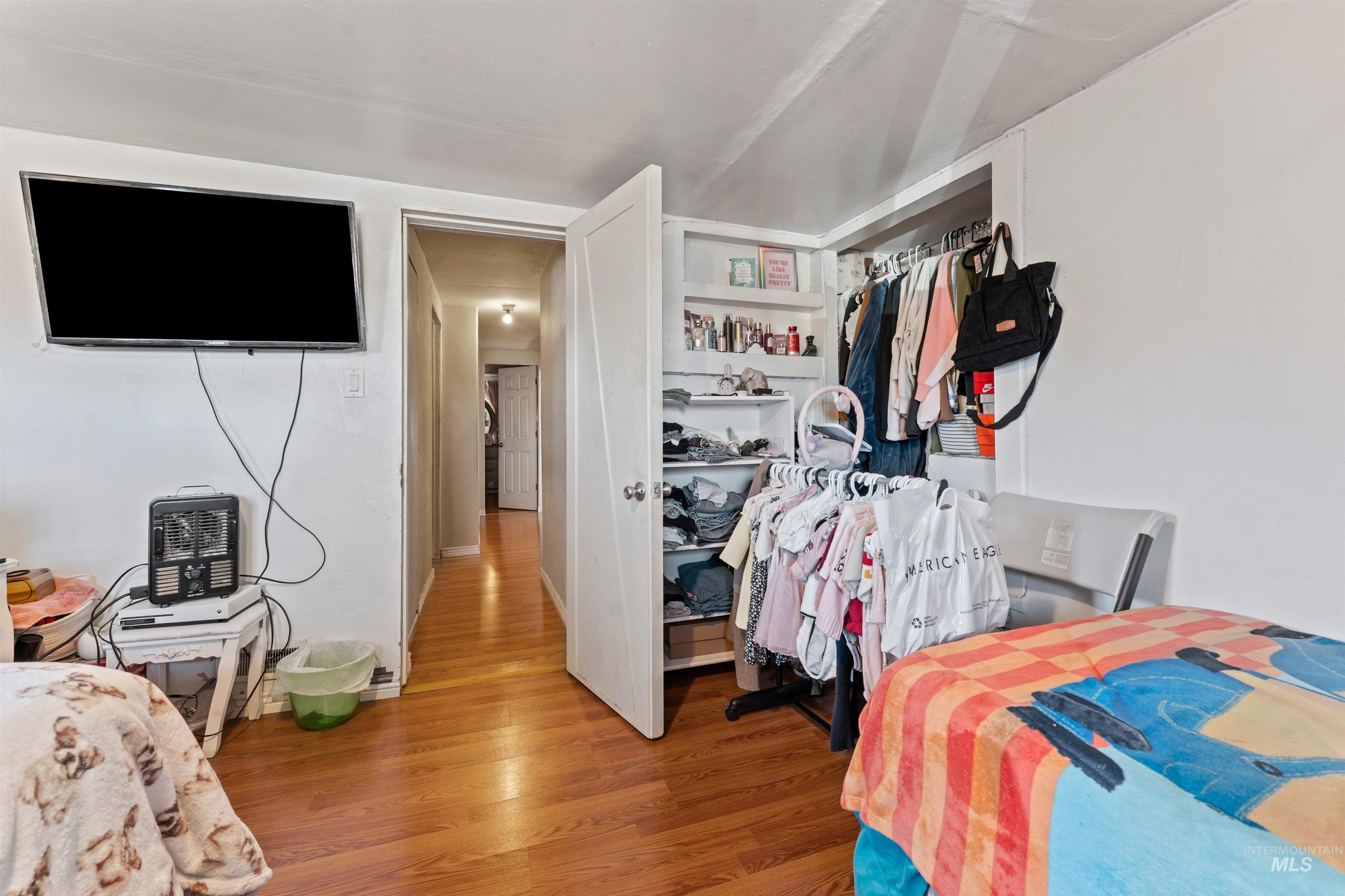 Bedroom with wood finished floors and a closet