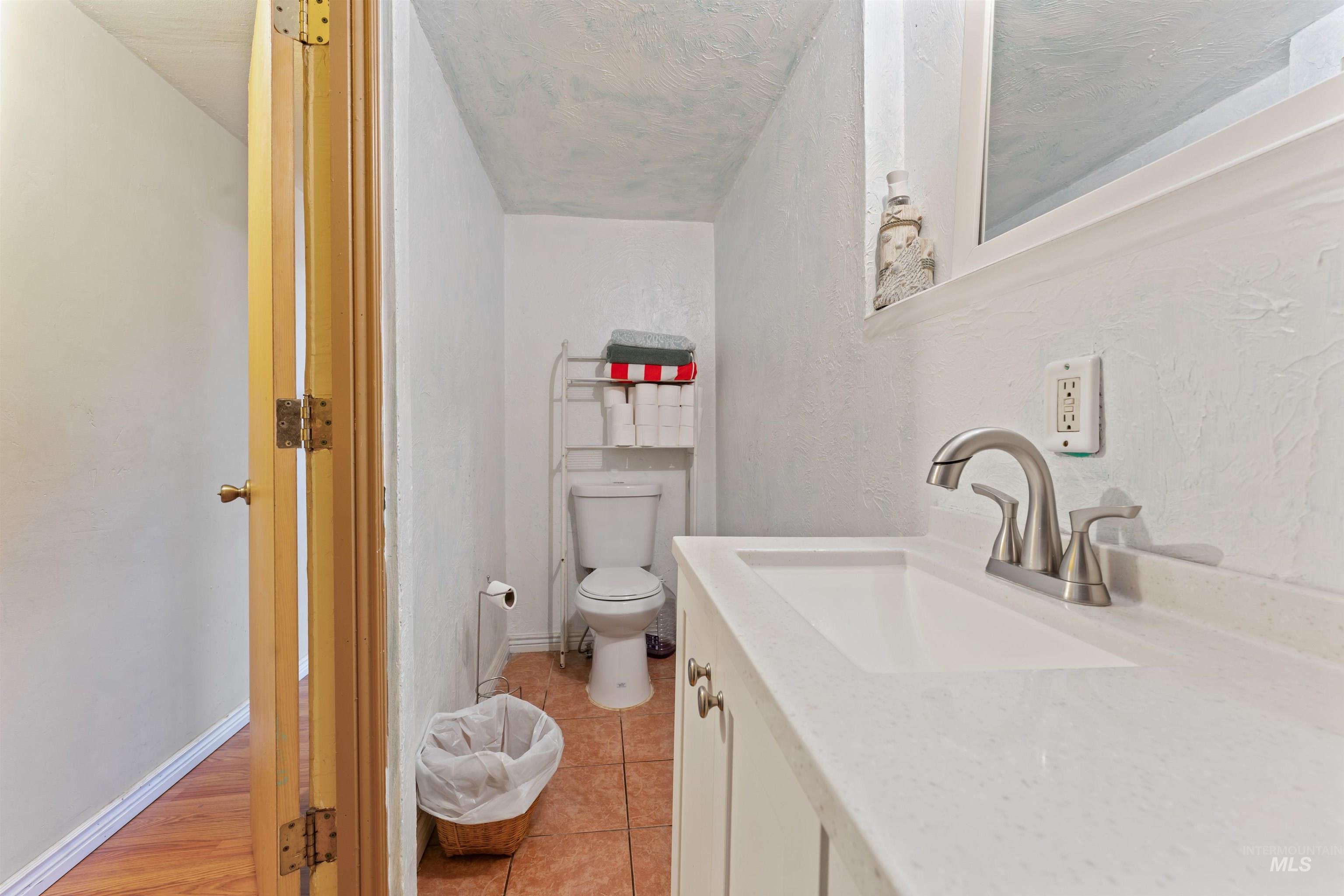 Bathroom featuring a textured wall and vanity