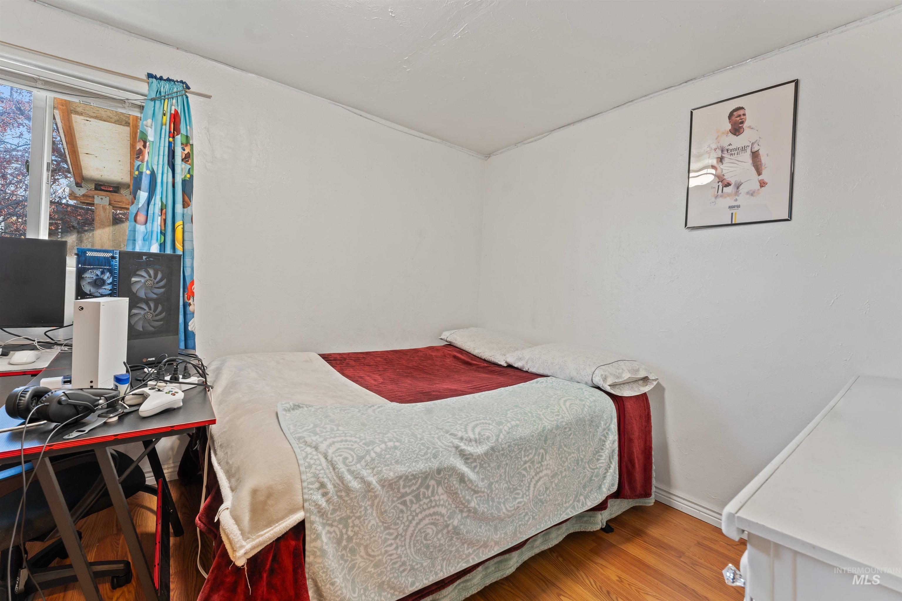 Bedroom featuring wood finished floors and an office area