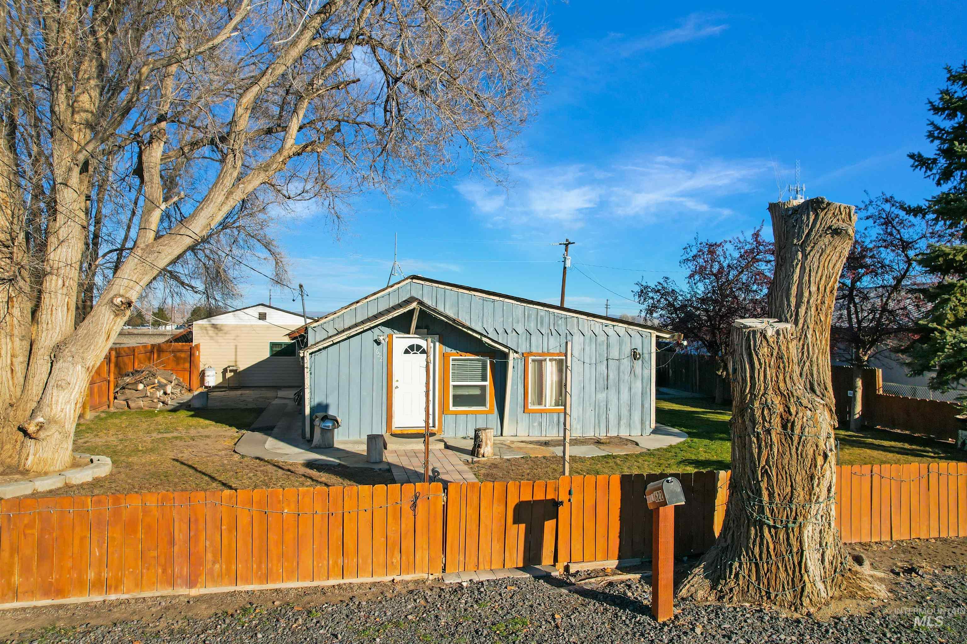 Rear view of house featuring a fenced front yard, board and batten siding, and a patio