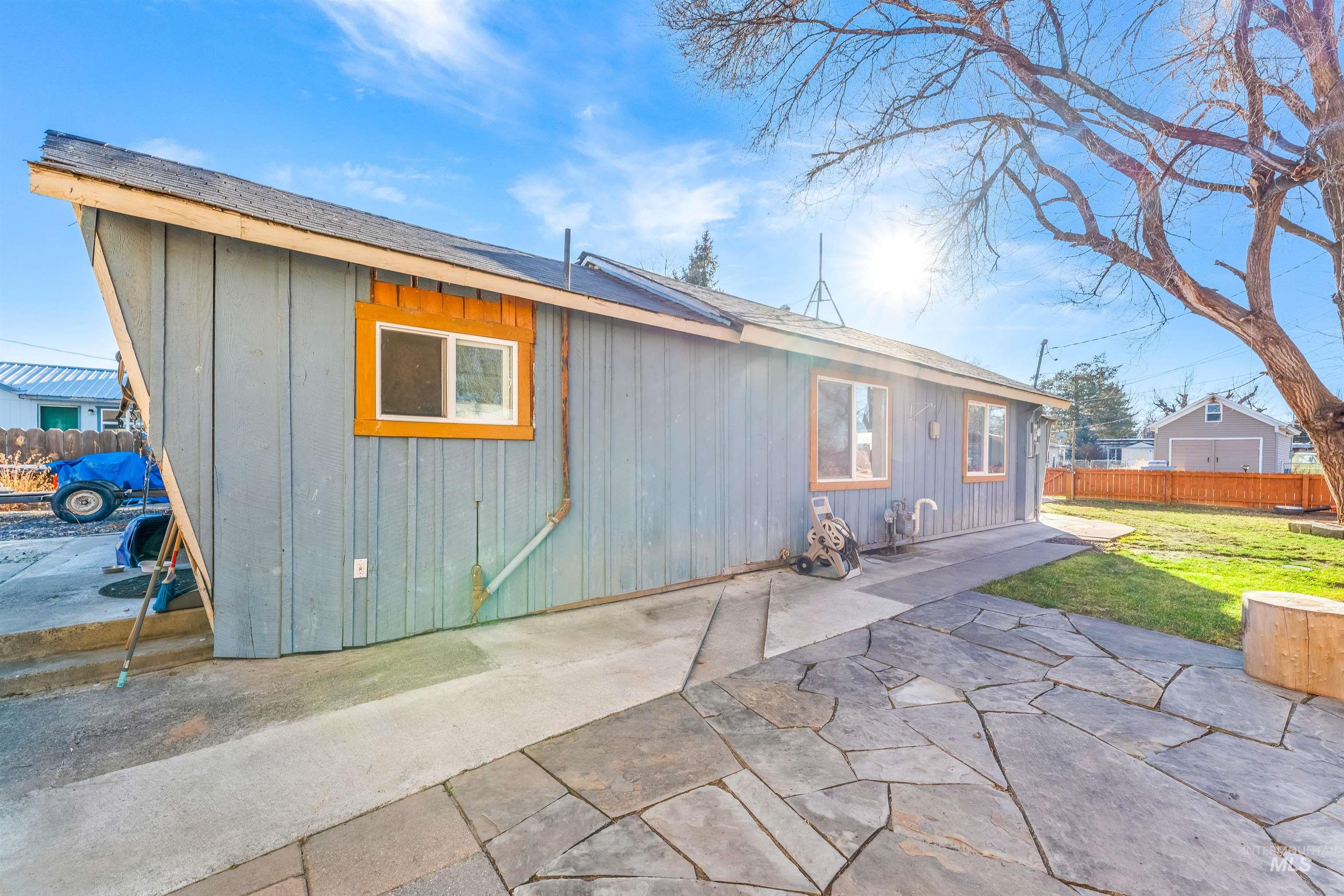 Back of house featuring a patio and roof with shingles