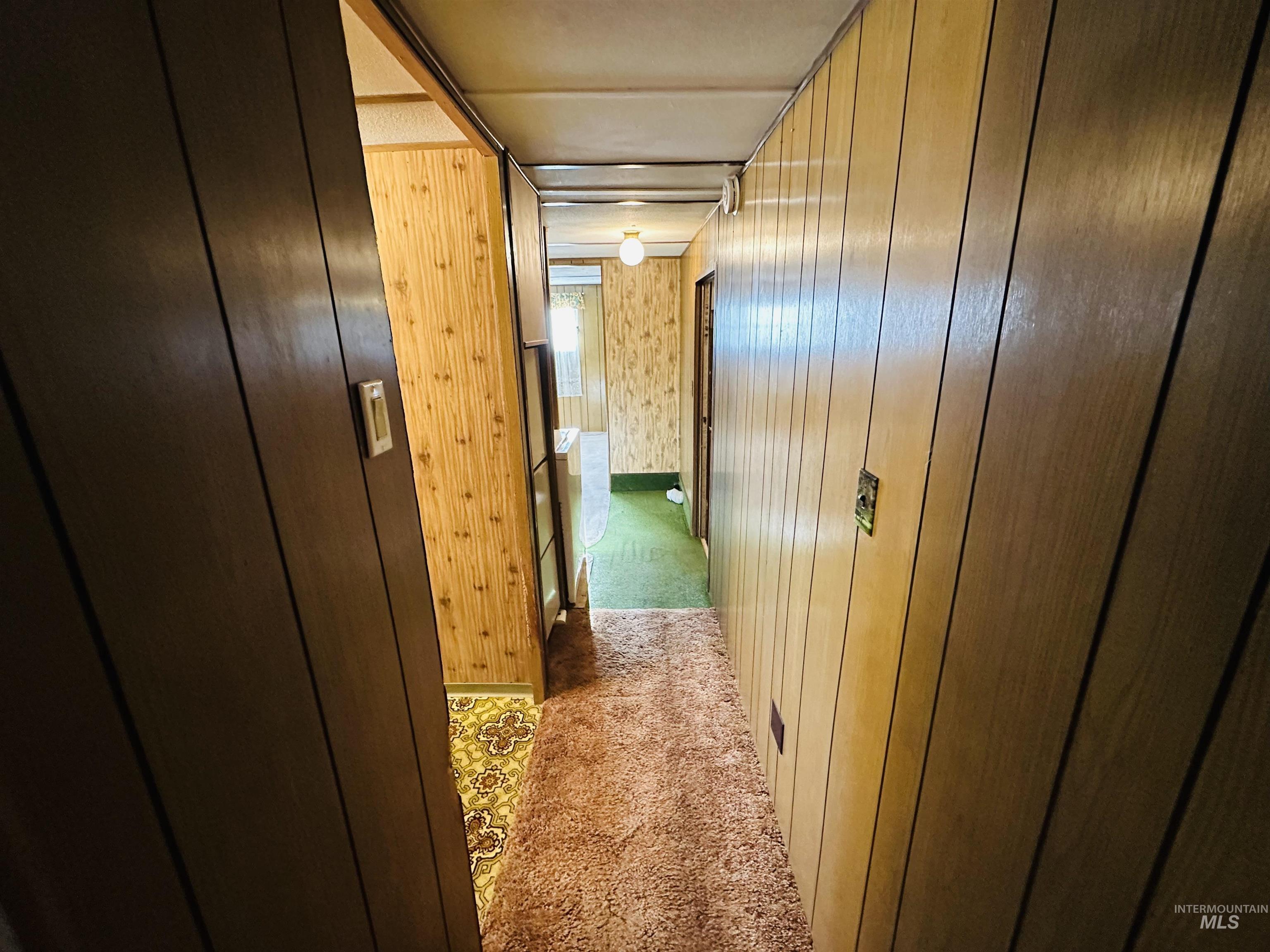 Hall featuring carpet floors and wood walls