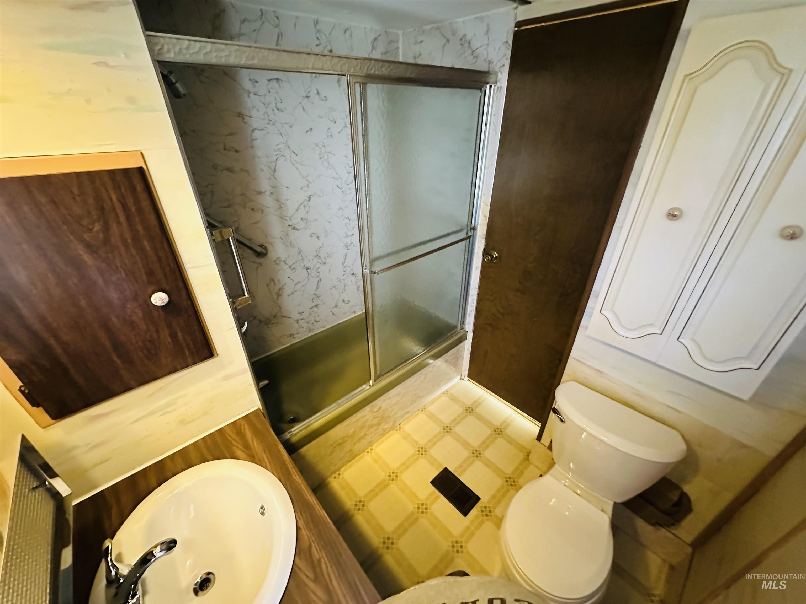 Bathroom featuring tile patterned floors, a stall shower, and vanity