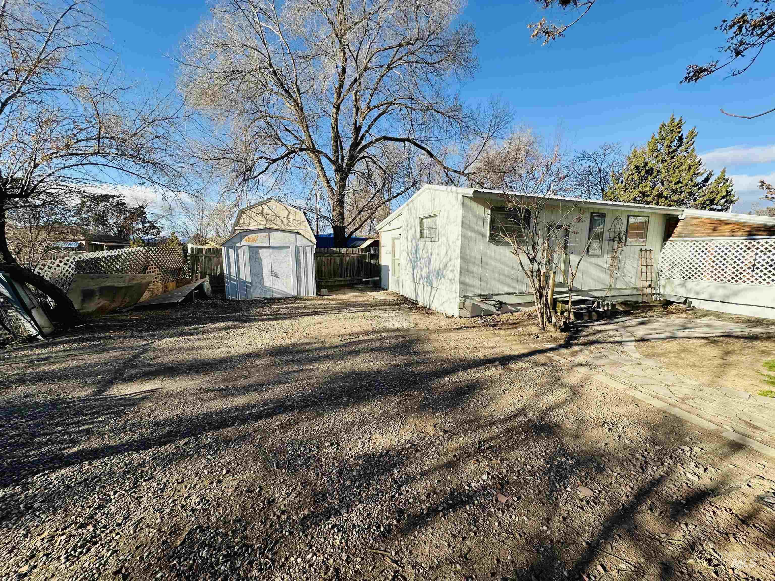 View of side of home featuring a fenced backyard and a storage shed