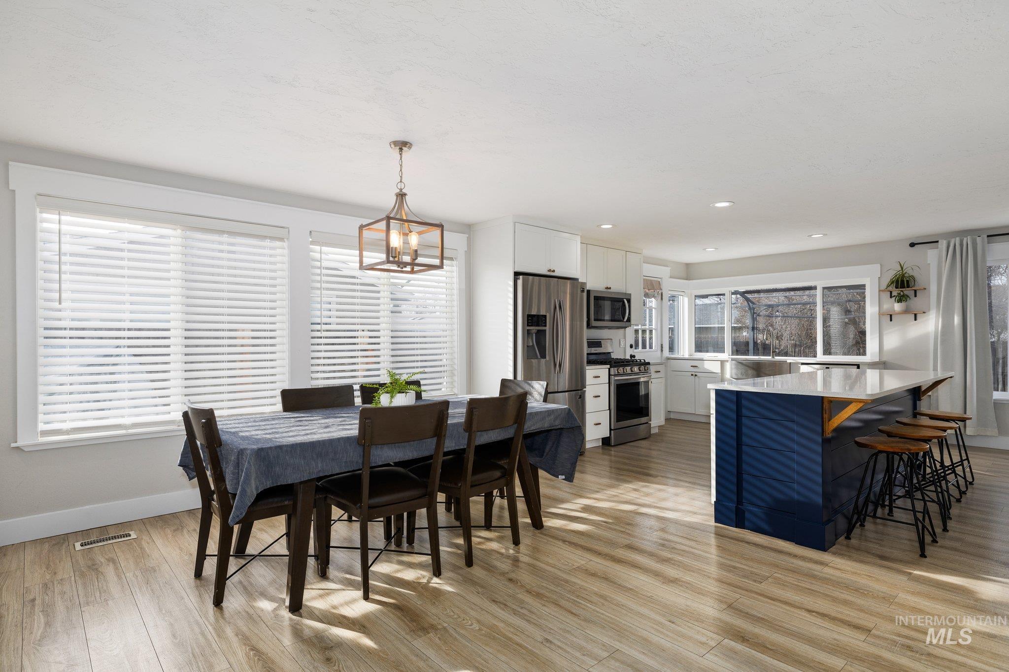 Dining area featuring light wood-type flooring, a chandelier, and recessed lighting