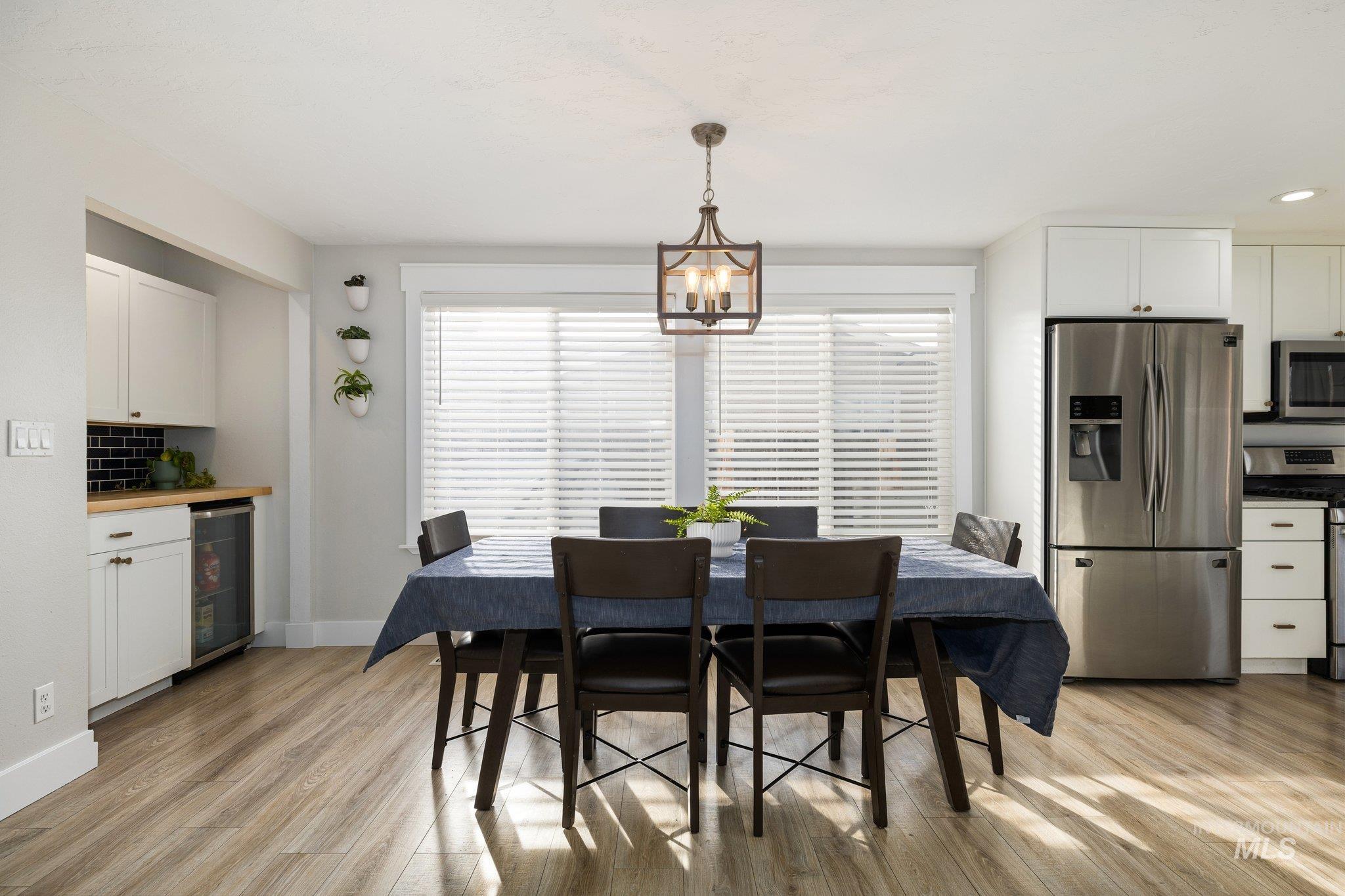 Dining room with beverage cooler and light wood finished floors
