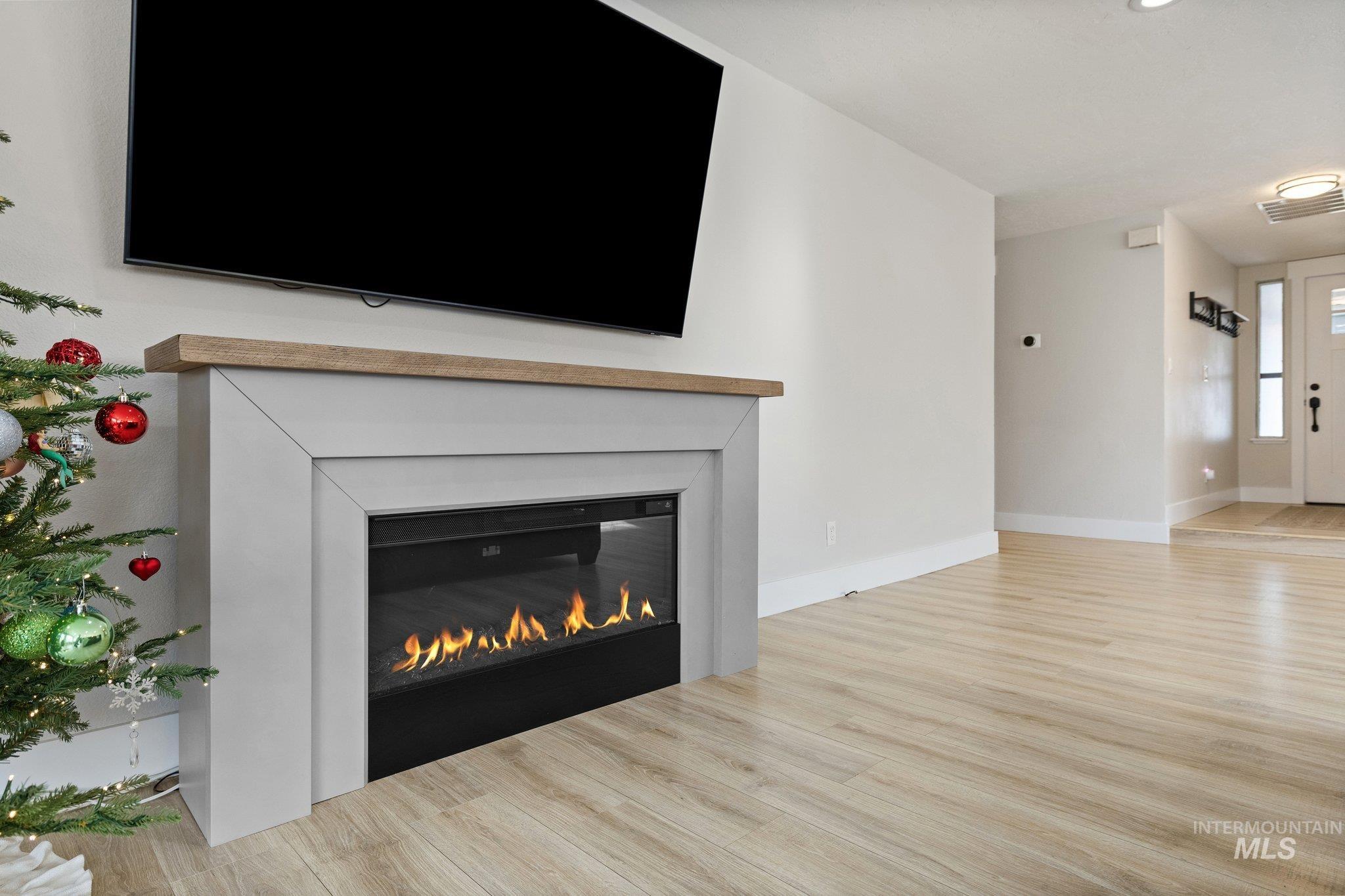 Detailed view of wood finished floors and a glass covered fireplace