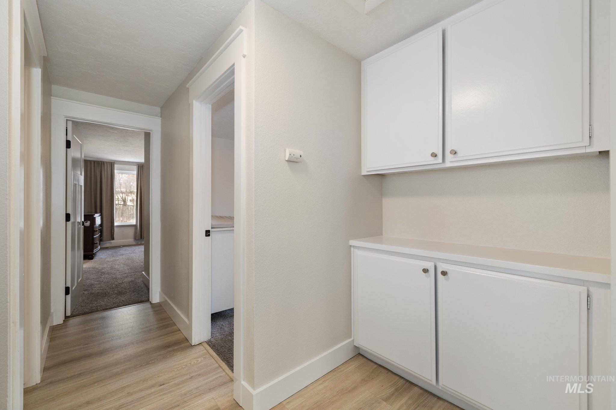 Corridor featuring baseboards and light wood-style flooring