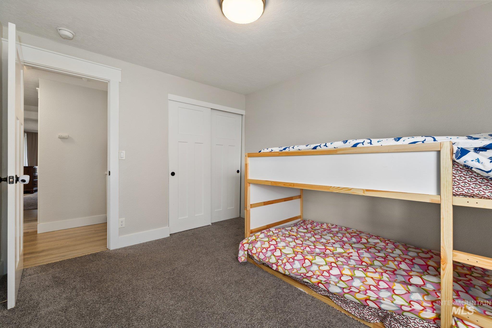 Carpeted bedroom featuring a closet and baseboards