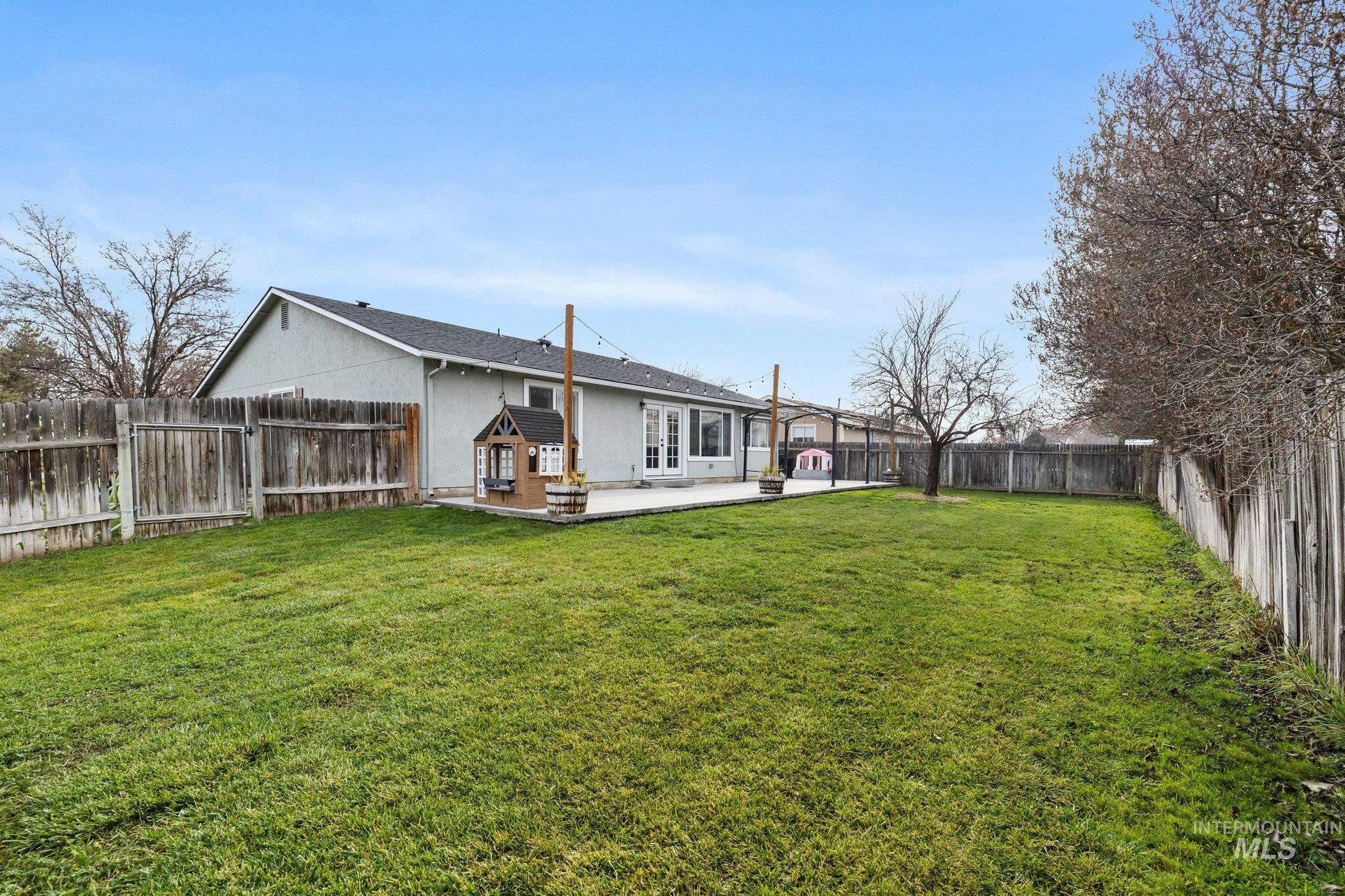 Rear view of property featuring a fenced backyard, a patio area, and stucco siding