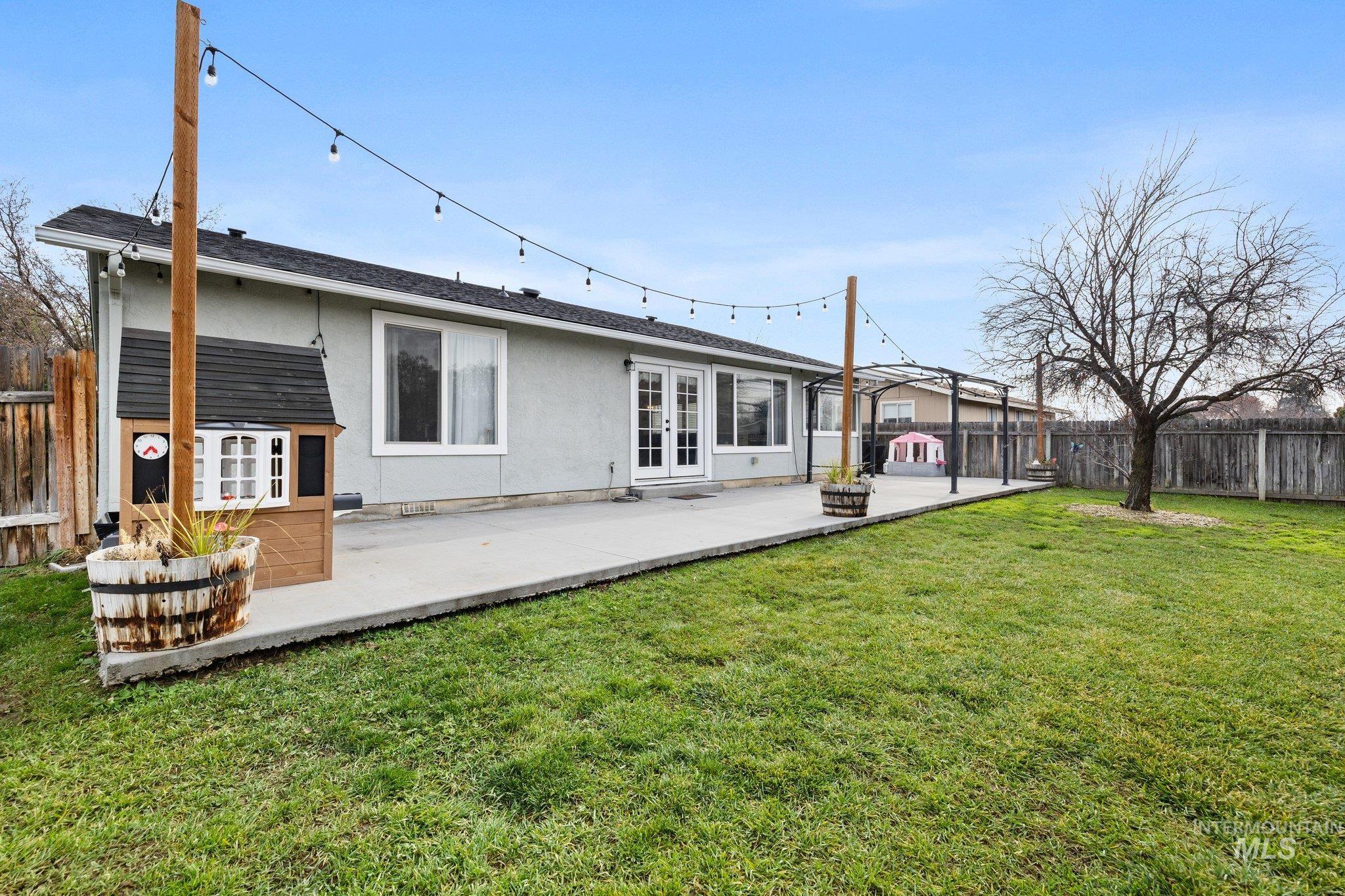 Back of house featuring a fenced backyard, stucco siding, a patio area, and french doors