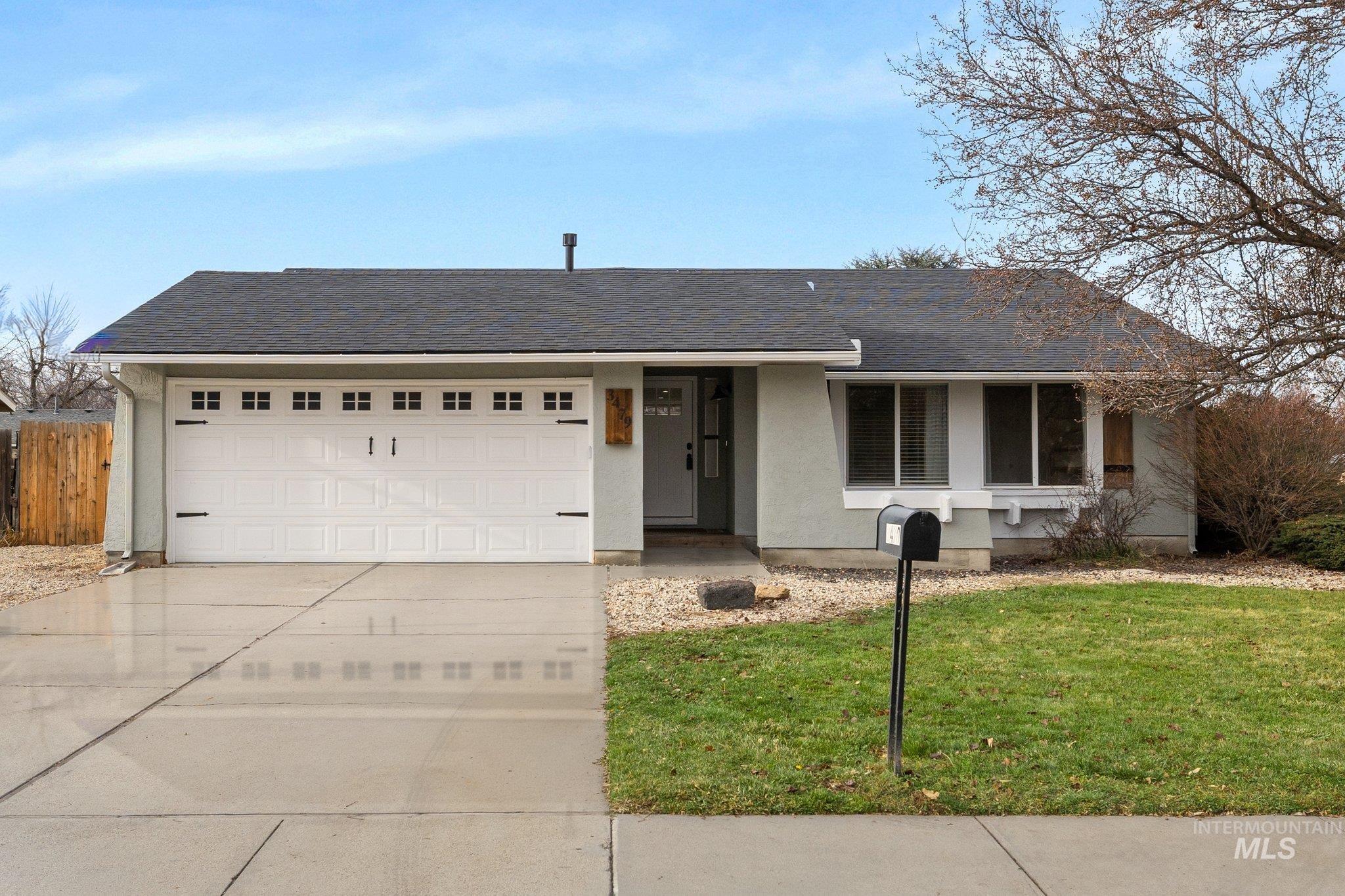 Single story home featuring roof with shingles, concrete driveway, stucco siding, and a garage