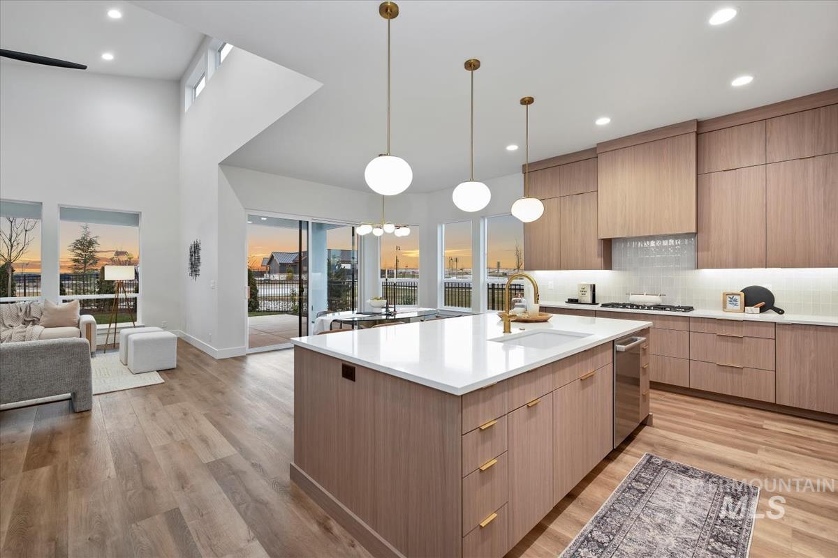 Kitchen with open floor plan, modern cabinets, light wood-type flooring, decorative light fixtures, and recessed lighting