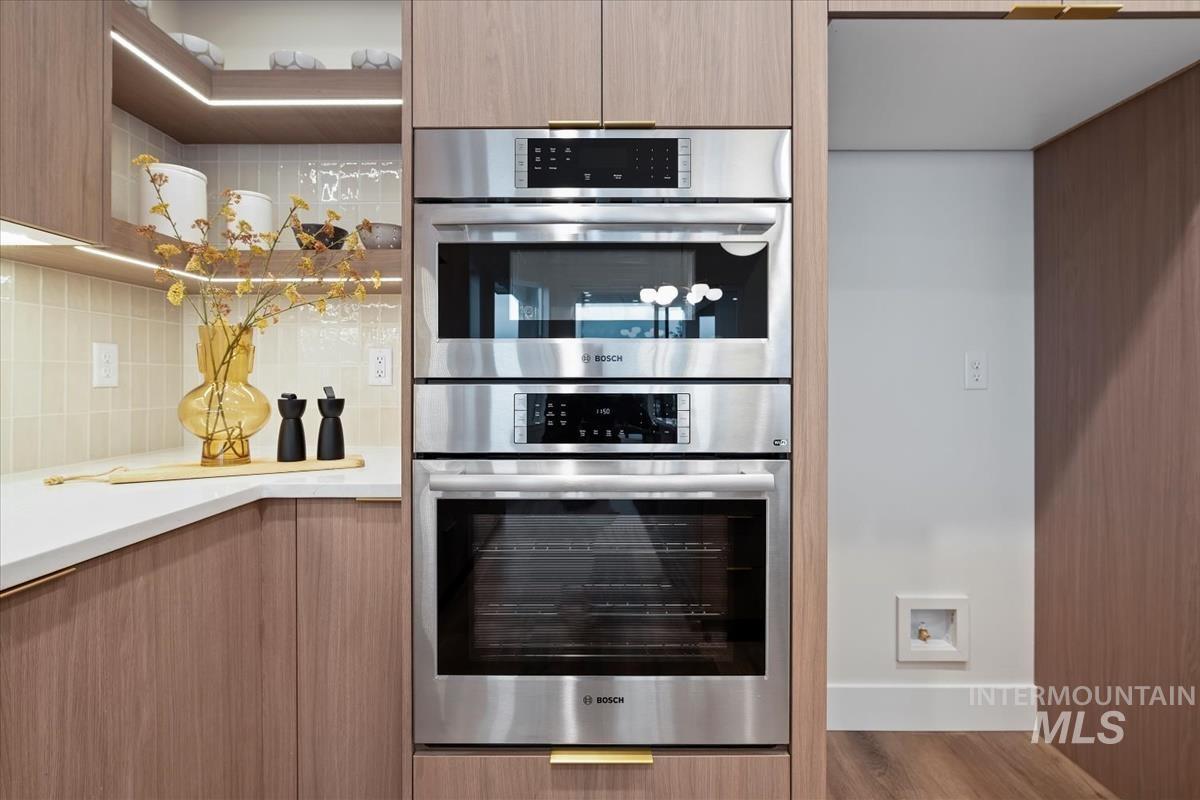 Kitchen featuring double oven, modern cabinets, and open shelves