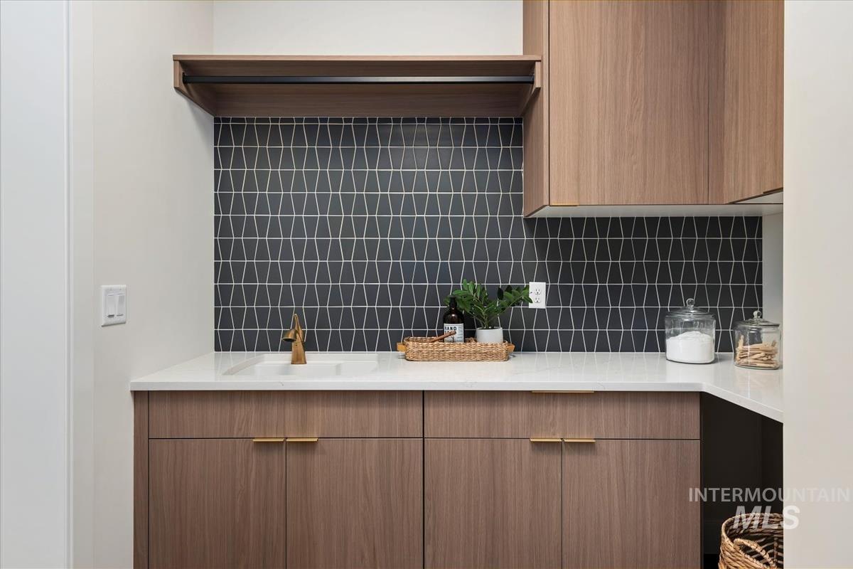 Bathroom featuring vanity and tasteful backsplash