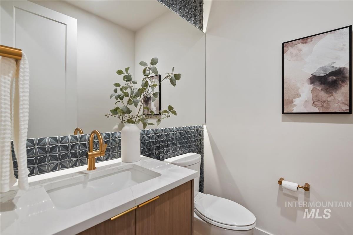 Half bathroom with decorative backsplash and vanity